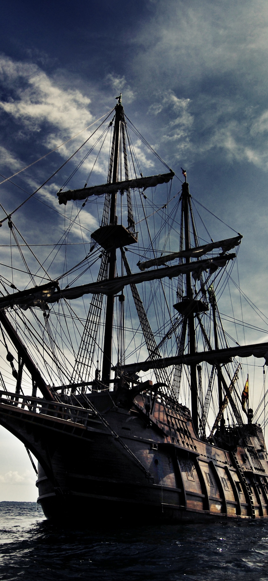 Barco Marrón en el Mar Bajo un Cielo Azul y Nubes Blancas Durante el Día. Wallpaper in 1125x2436 Resolution