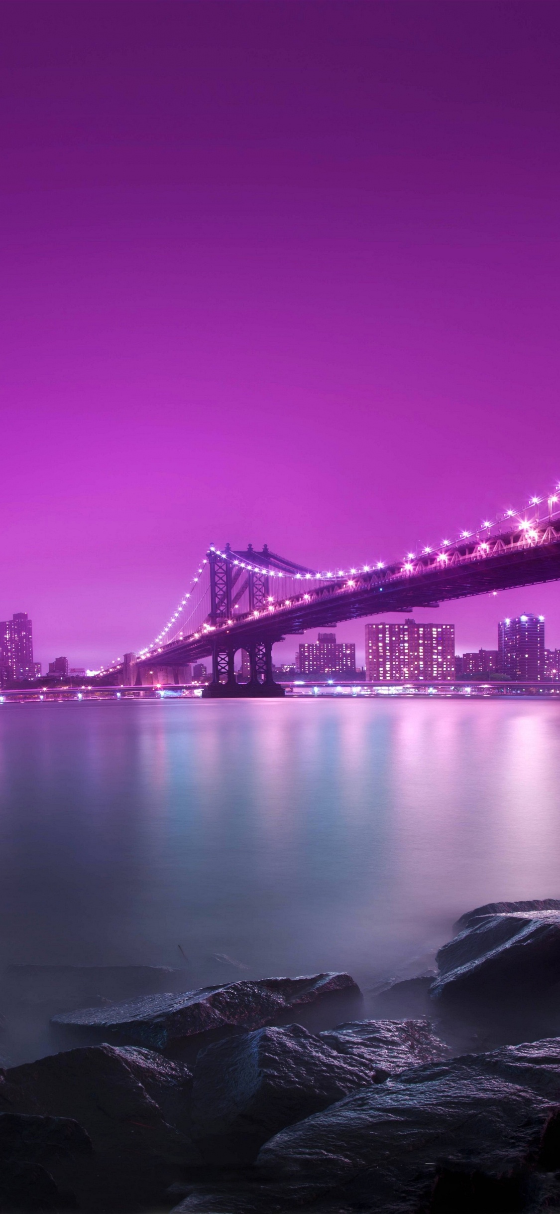 Black Bridge Over Body of Water During Night Time. Wallpaper in 1125x2436 Resolution