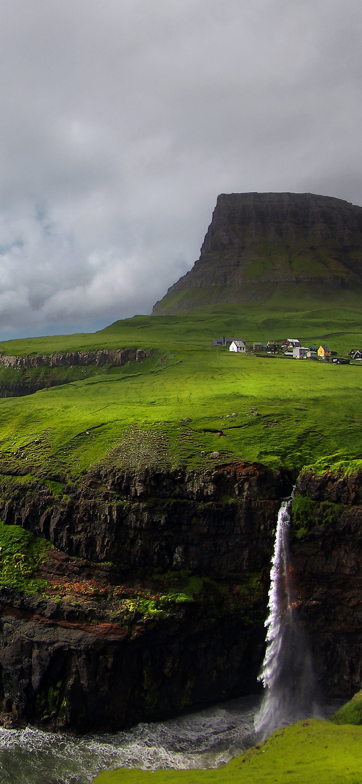 Montaña Verde y Marrón Junto al Mar Bajo un Cielo Nublado Durante el Día. Wallpaper in 1242x2688 Resolution