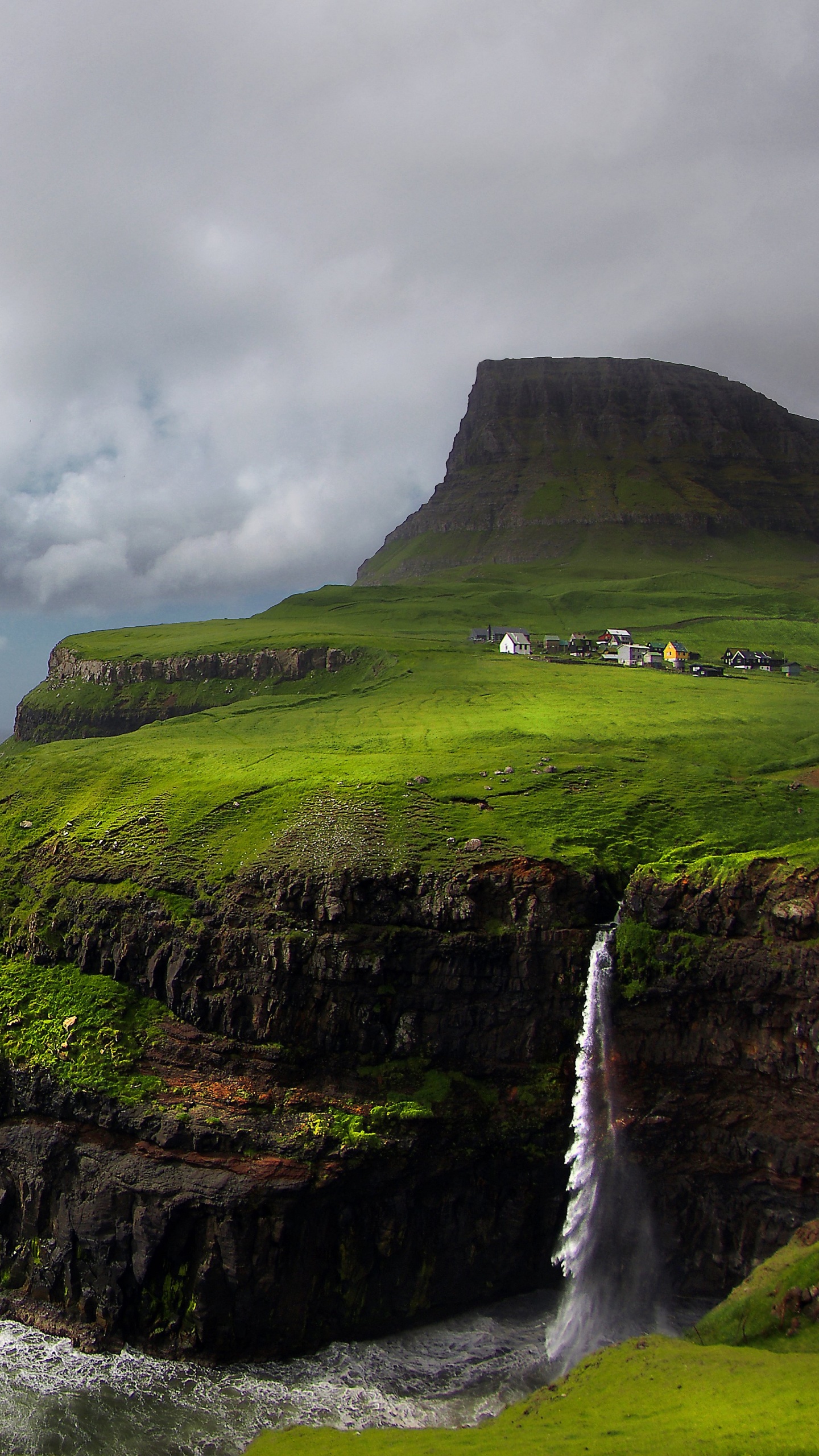 Montaña Verde y Marrón Junto al Mar Bajo un Cielo Nublado Durante el Día. Wallpaper in 1440x2560 Resolution
