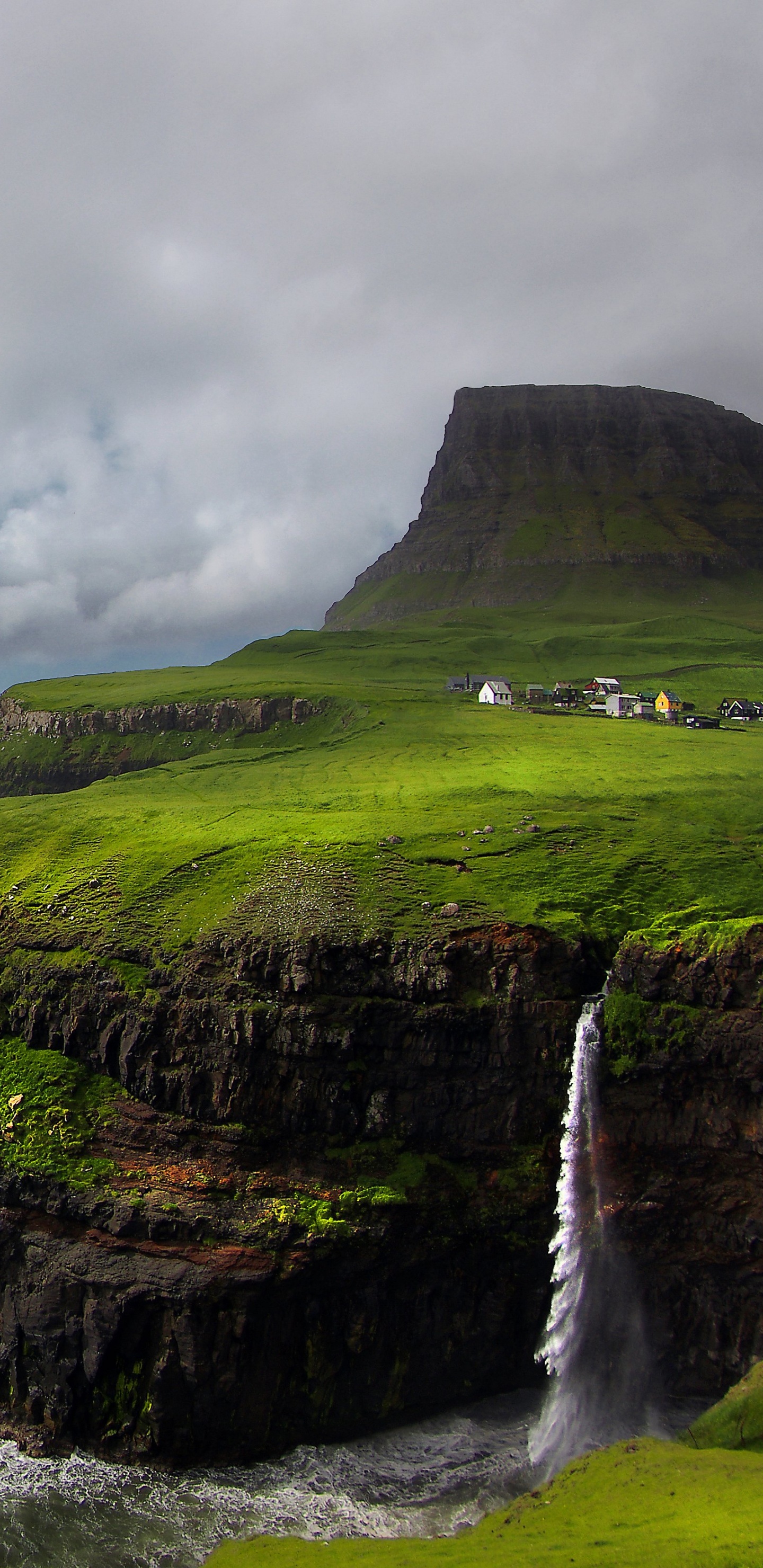 Montaña Verde y Marrón Junto al Mar Bajo un Cielo Nublado Durante el Día. Wallpaper in 1440x2960 Resolution