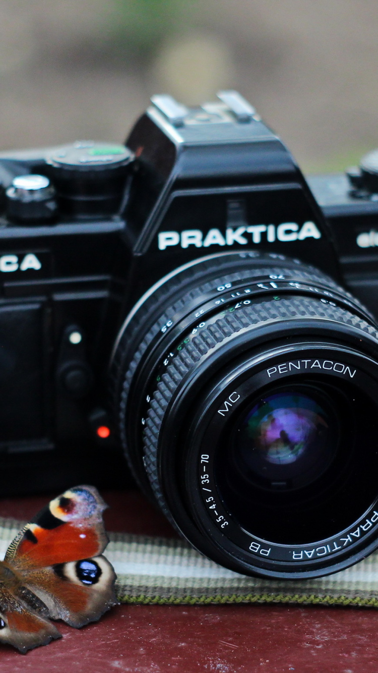 Black Nikon Dslr Camera on Brown Textile. Wallpaper in 750x1334 Resolution