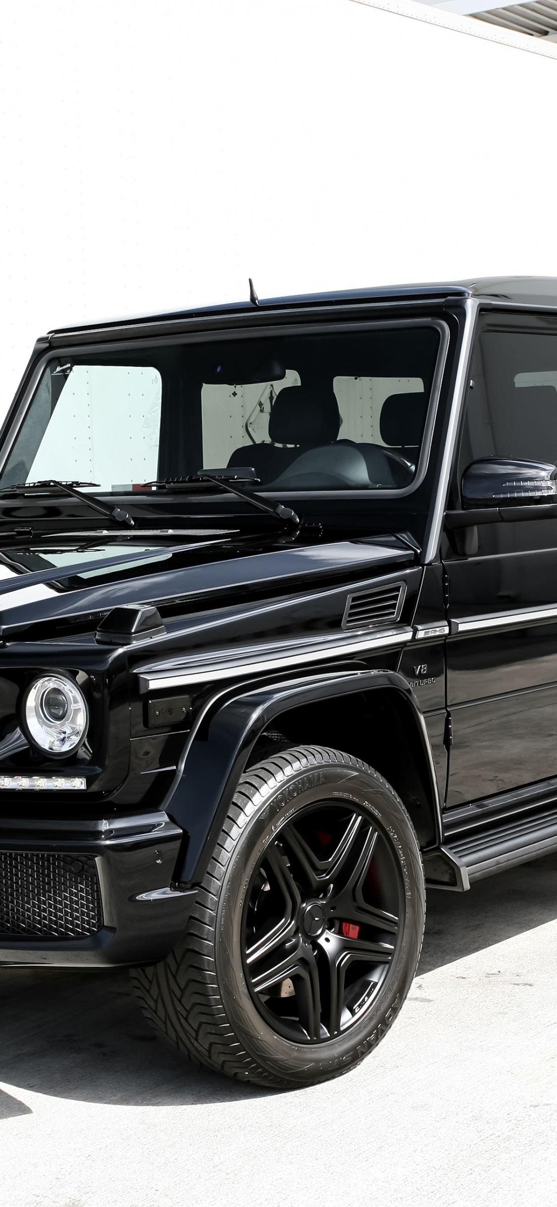 Black Suv on Gray Concrete Road During Daytime. Wallpaper in 1125x2436 Resolution