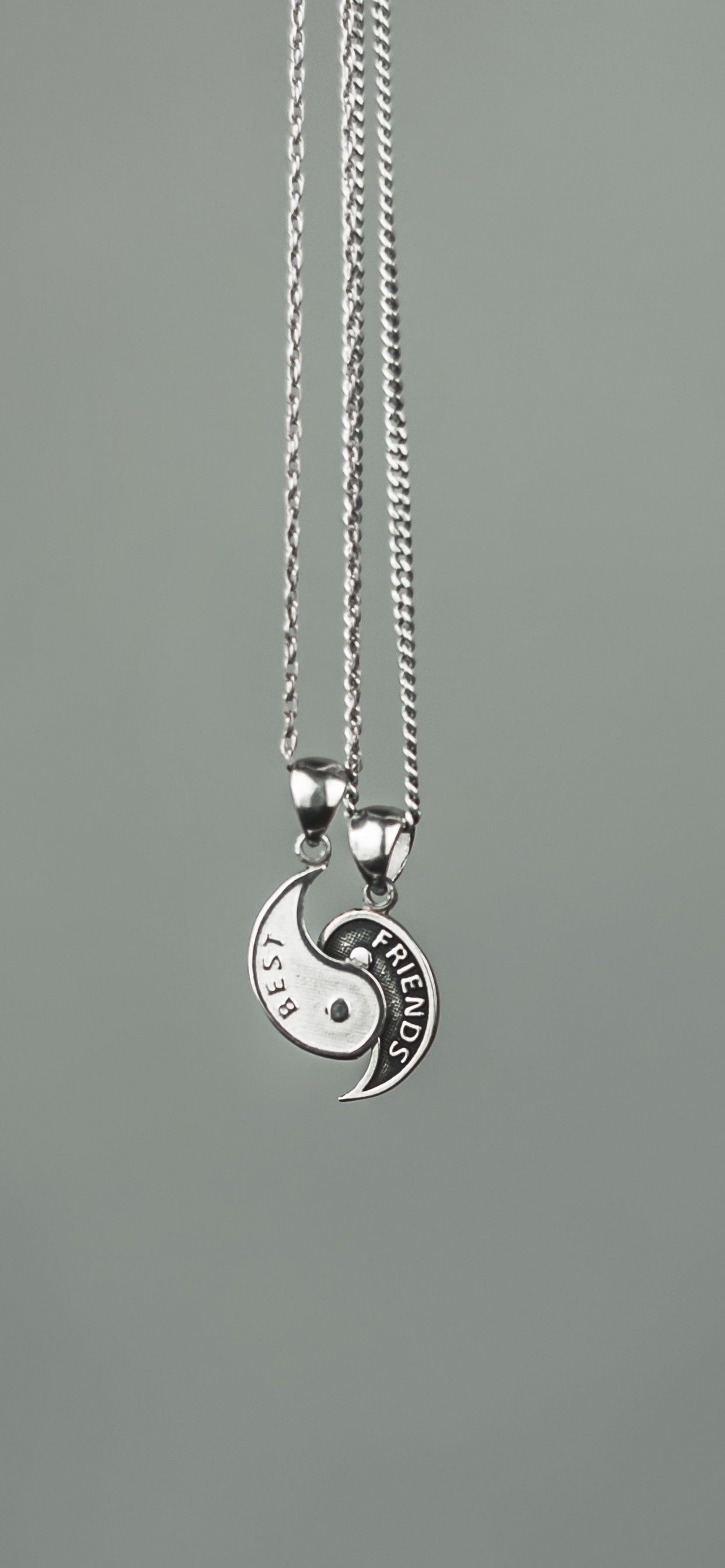 Silver Heart Pendant Necklace on Green Surface. Wallpaper in 1242x2688 Resolution