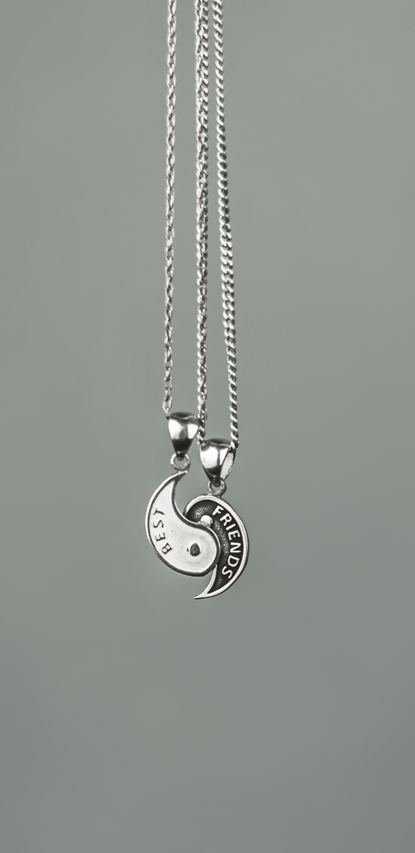 Silver Heart Pendant Necklace on Green Surface. Wallpaper in 1440x2960 Resolution