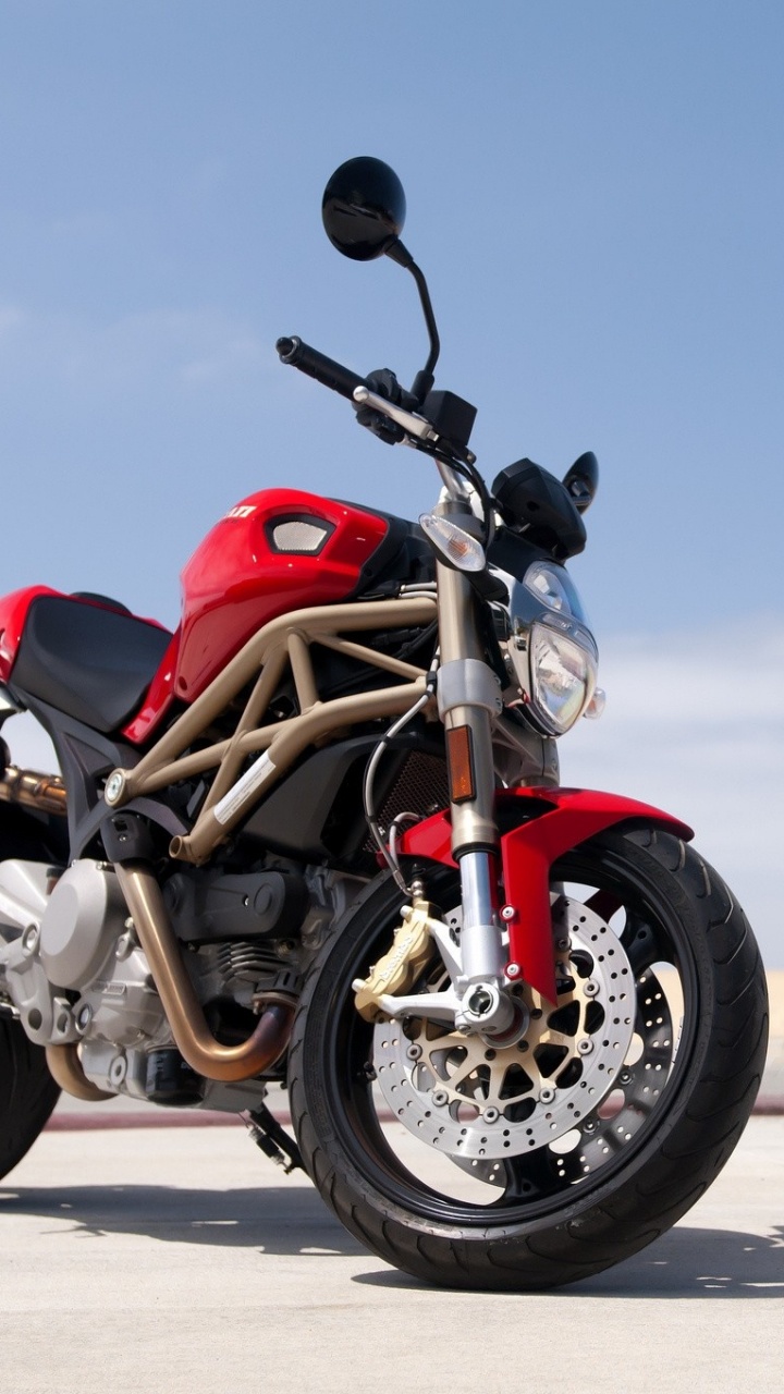 Moto Rouge et Noire Sur Sable Gris Pendant la Journée. Wallpaper in 720x1280 Resolution