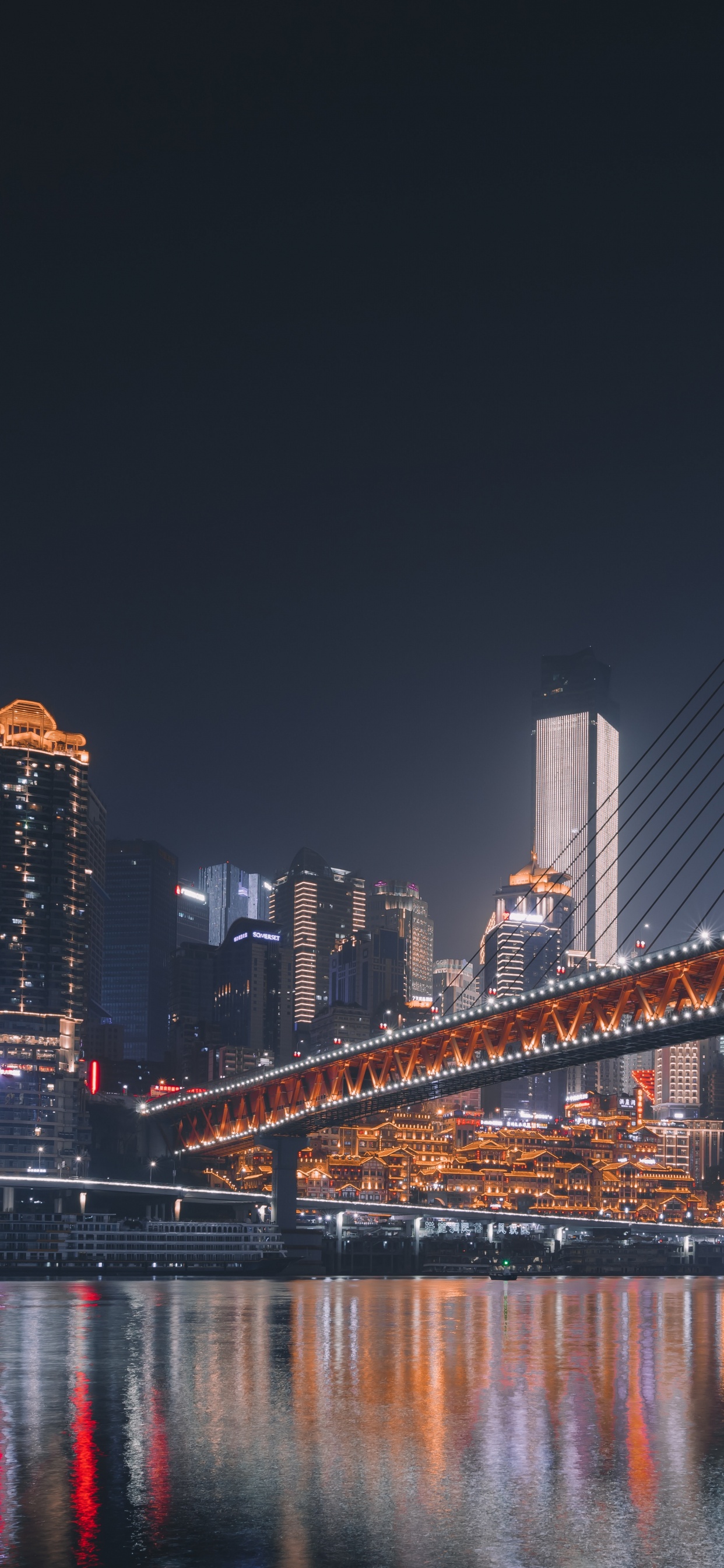 Blaue Brücke Über Wasser Während Der Nacht Night. Wallpaper in 1242x2688 Resolution