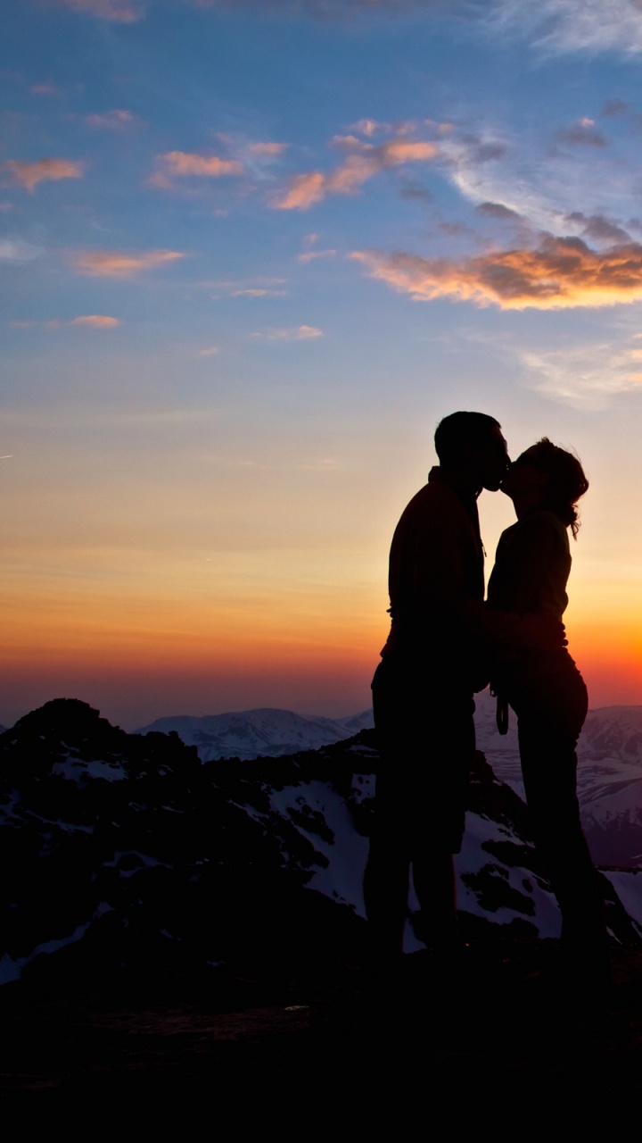 Silueta de Pareja Besándose en la Cima de la Montaña Durante el Atardecer. Wallpaper in 720x1280 Resolution