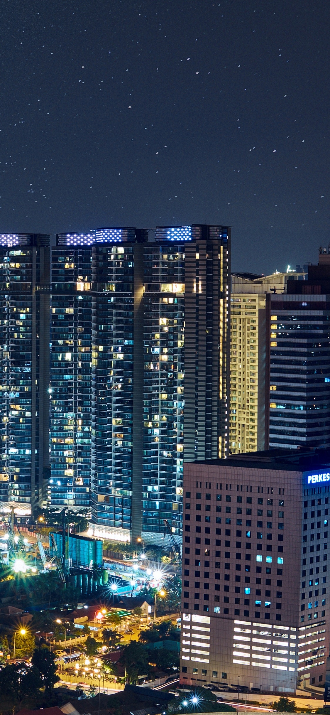 City With High Rise Buildings During Night Time. Wallpaper in 1125x2436 Resolution
