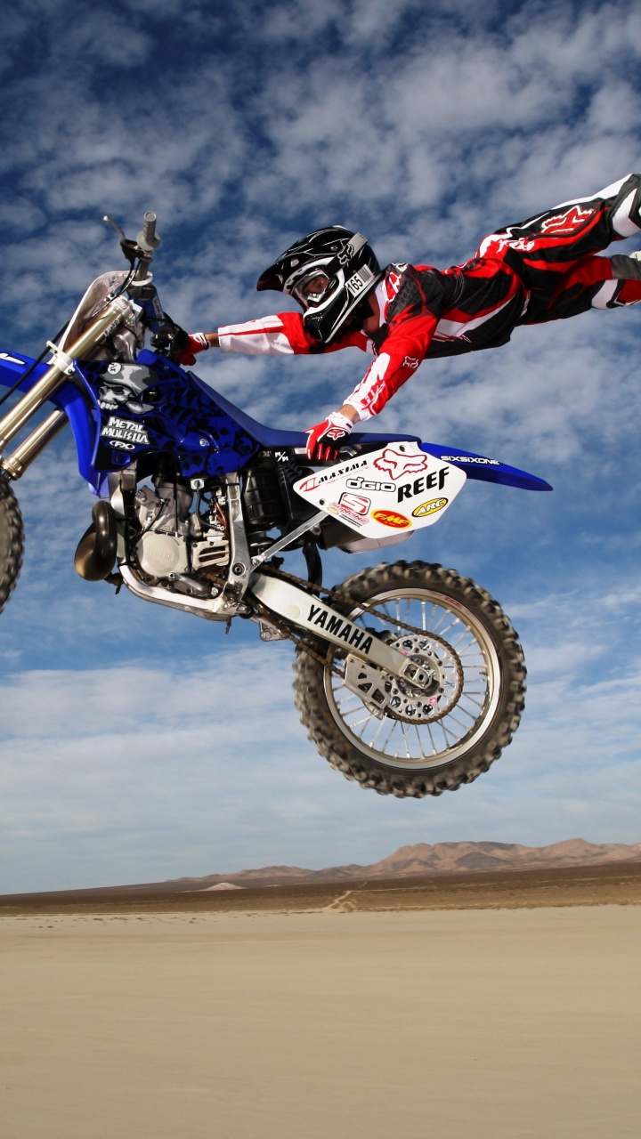 Man Riding Motocross Dirt Bike Sur Sable Brun Sous Ciel Bleu Pendant la Journée. Wallpaper in 720x1280 Resolution