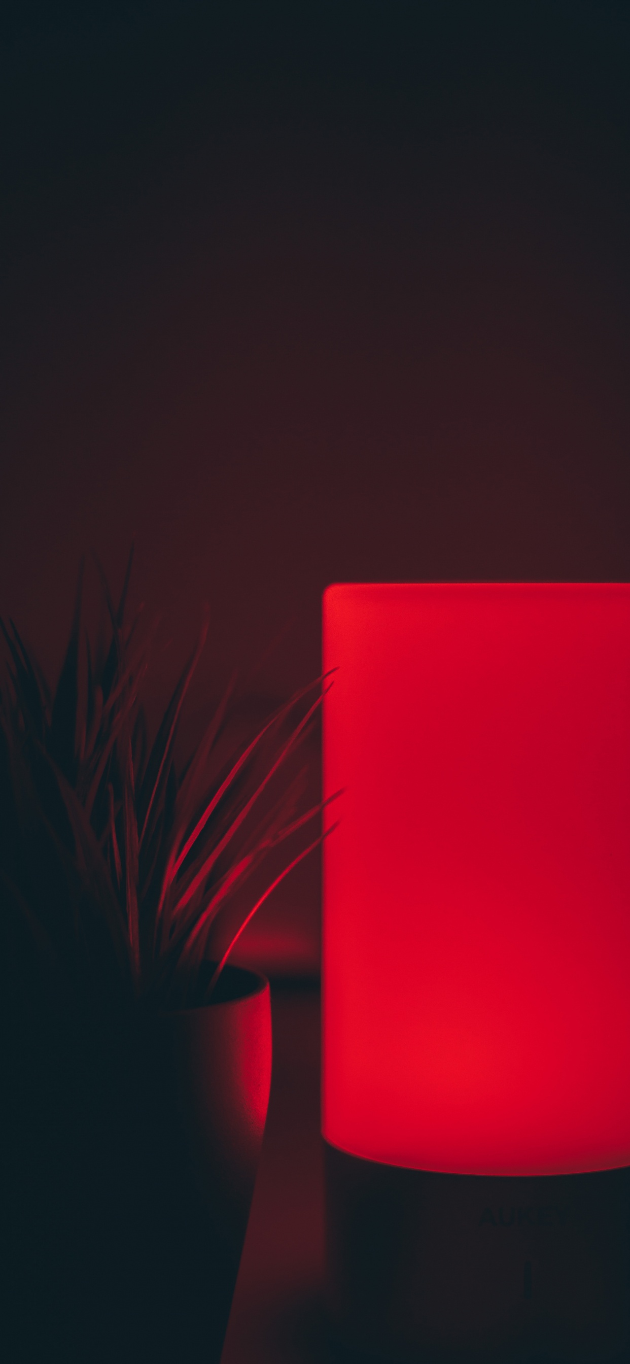 Dispositivo Rectangular Rojo Sobre Superficie Negra. Wallpaper in 1242x2688 Resolution