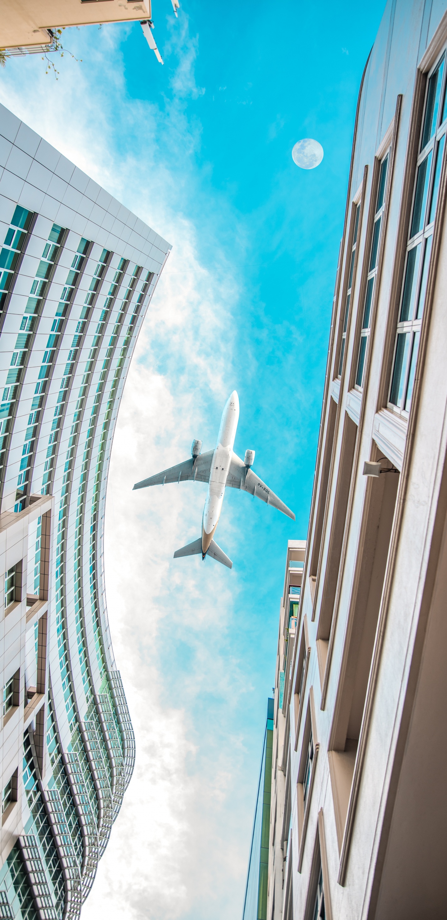 Avión Blanco Volando Sobre el Edificio de Gran Altura Durante el Día. Wallpaper in 1440x2960 Resolution