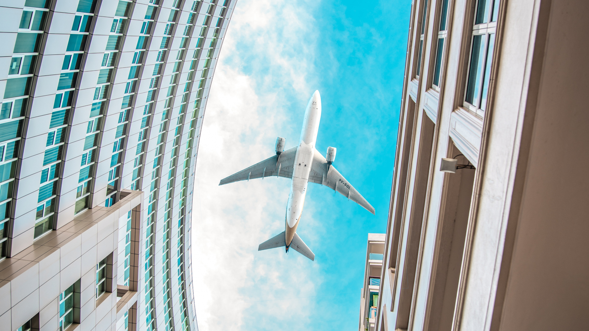 Avión Blanco Volando Sobre el Edificio de Gran Altura Durante el Día. Wallpaper in 1920x1080 Resolution