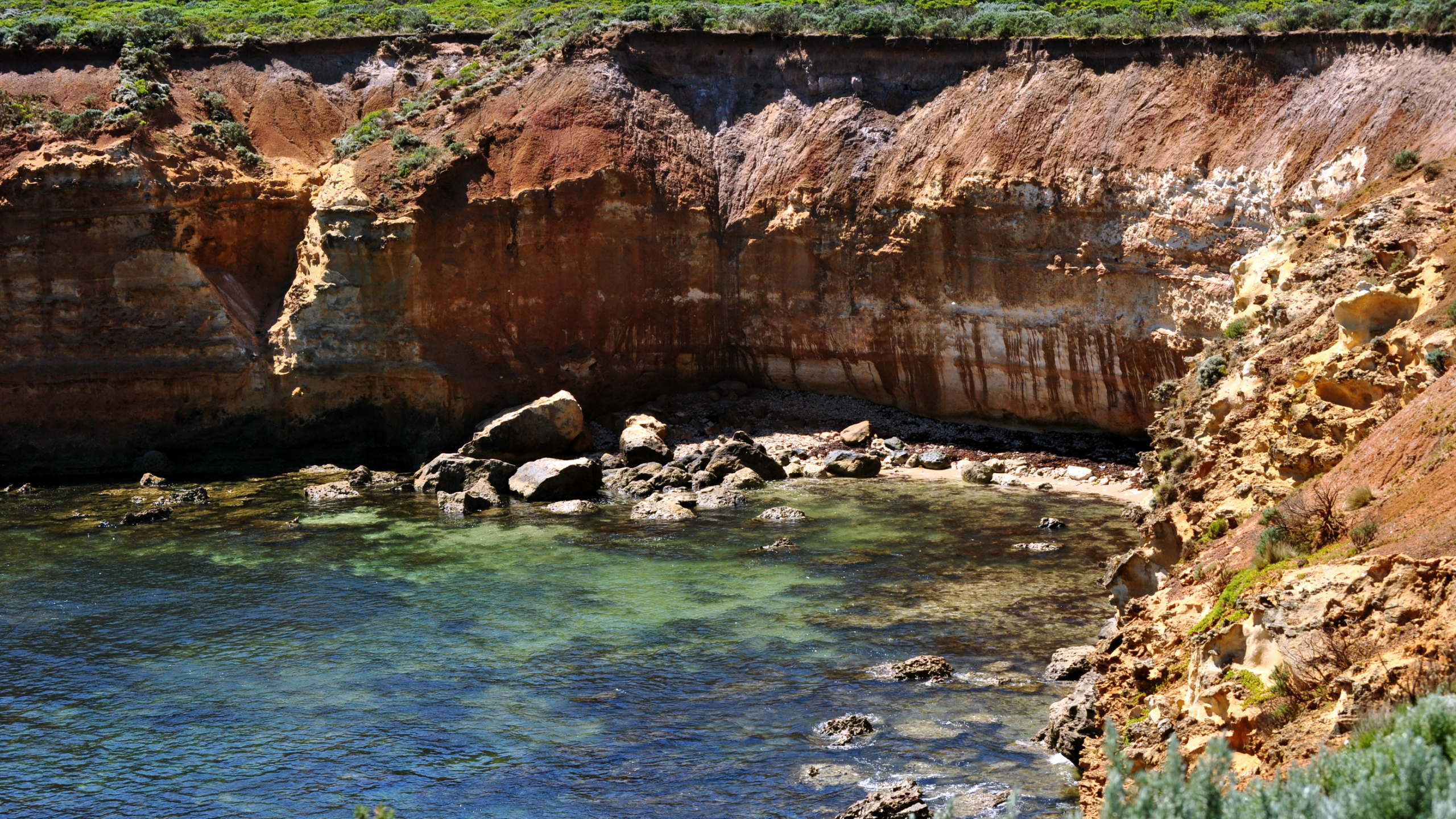 Brown Rock Formation Beside Blue Sea During Daytime. Wallpaper in 2560x1440 Resolution
