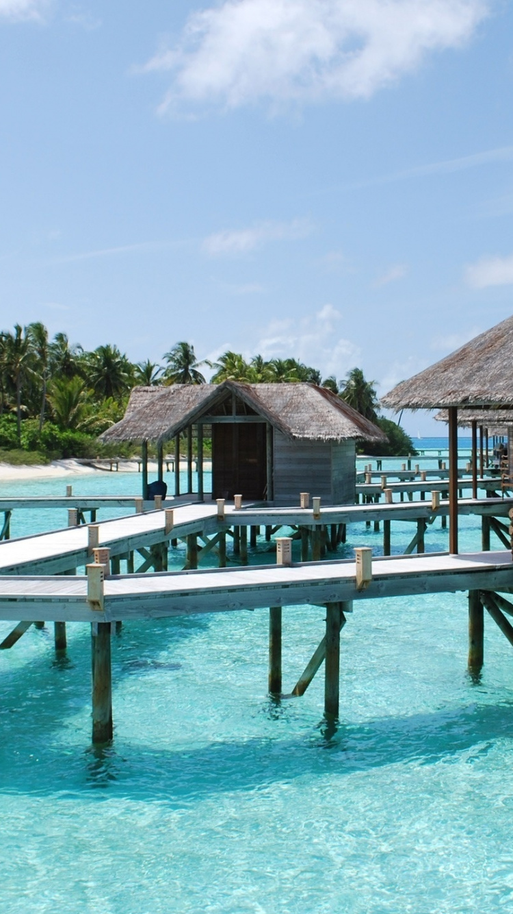 Brown Wooden House on Blue Sea Under Blue Sky During Daytime. Wallpaper in 750x1334 Resolution