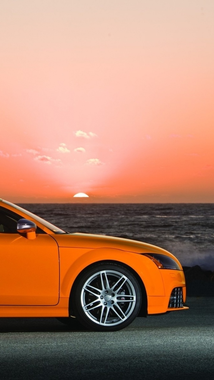 Porsche 911 Amarillo Sobre Pavimento de Hormigón Gris Cerca Del Cuerpo de Agua Durante la Puesta de Sol. Wallpaper in 720x1280 Resolution