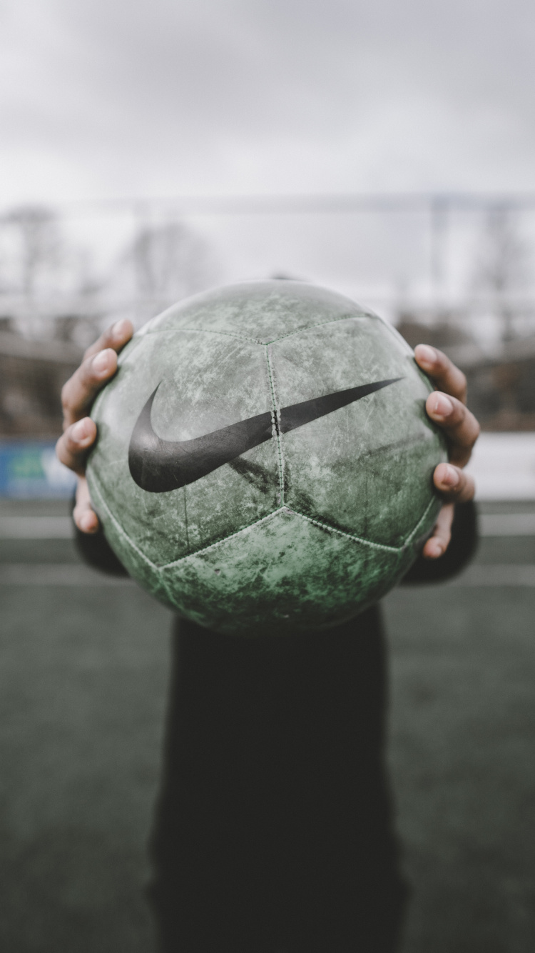 Person Holding Green and Black Ball. Wallpaper in 750x1334 Resolution