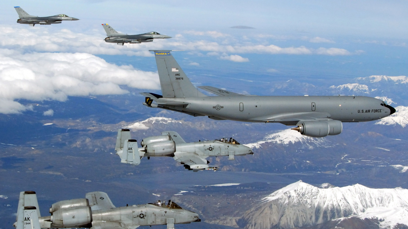 Avión de Combate Gris Volando Sobre Montañas Cubiertas de Nieve Durante el Día. Wallpaper in 1366x768 Resolution