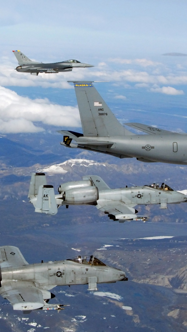 Avión de Combate Gris Volando Sobre Montañas Cubiertas de Nieve Durante el Día. Wallpaper in 720x1280 Resolution