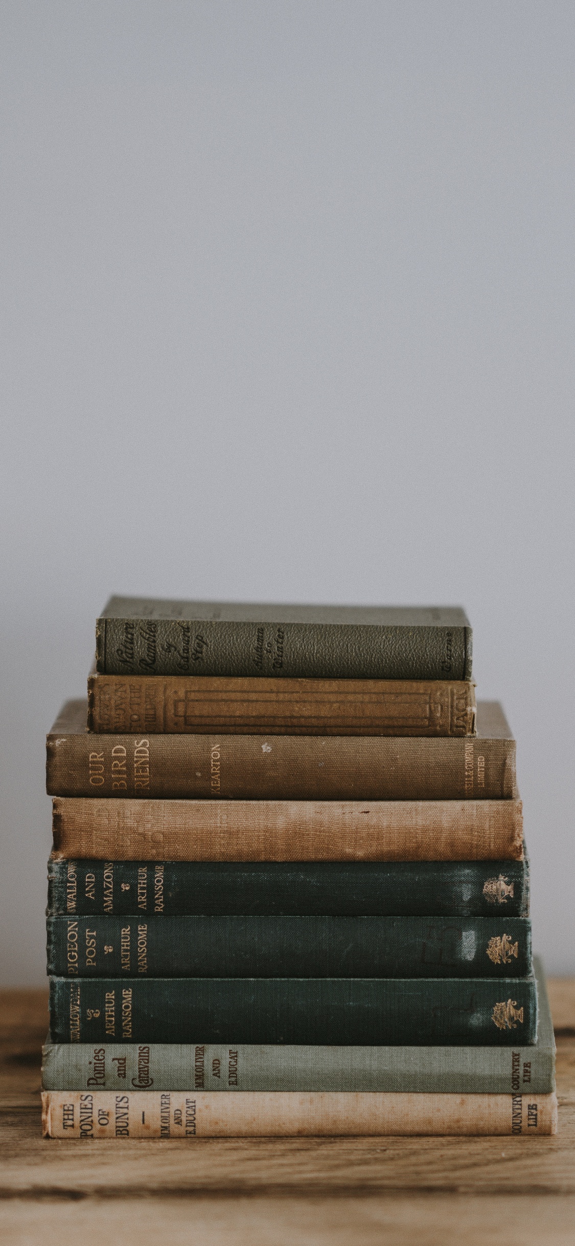 Stapel Bücher Auf Braunem Holztisch. Wallpaper in 1125x2436 Resolution