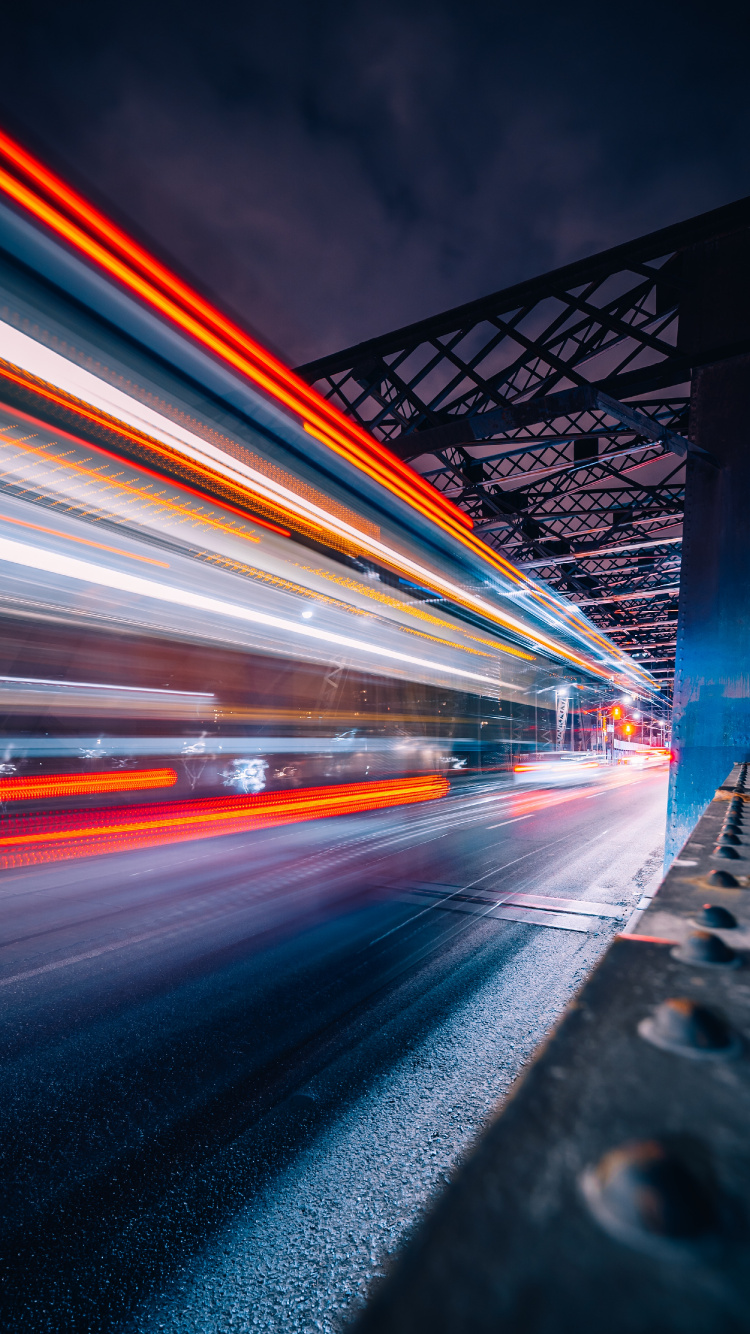 Zeitrafferaufnahmen Von Autos Auf Der Brücke Bei Nacht. Wallpaper in 750x1334 Resolution
