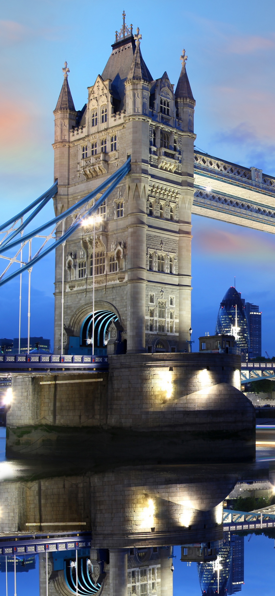 People Walking on Bridge Near White Concrete Building During Night Time. Wallpaper in 1125x2436 Resolution
