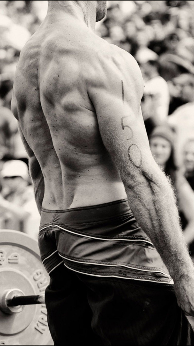 Oben Ohne Mann in Schwarzen Shorts Mit Langhantel Bar. Wallpaper in 750x1334 Resolution