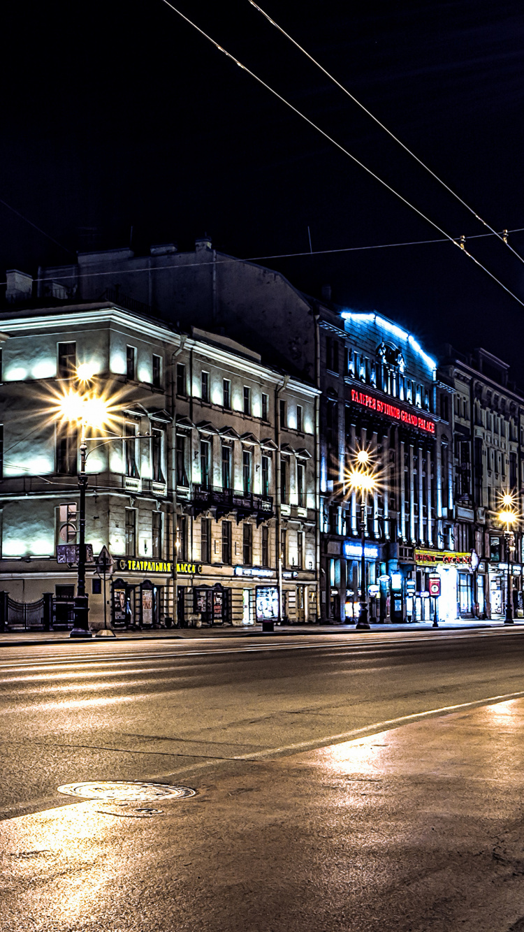Stadtgebäude Mit Nachts Eingeschaltetem Licht. Wallpaper in 750x1334 Resolution