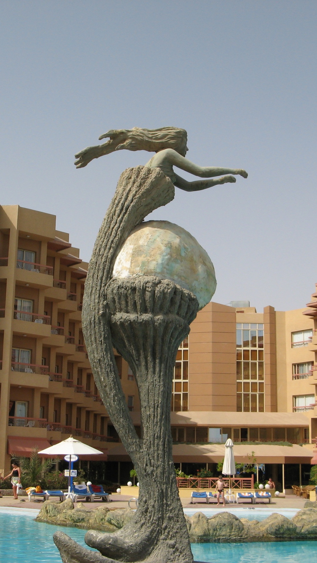 Clear Glass Bird Statue Near Brown Concrete Building During Daytime. Wallpaper in 1080x1920 Resolution