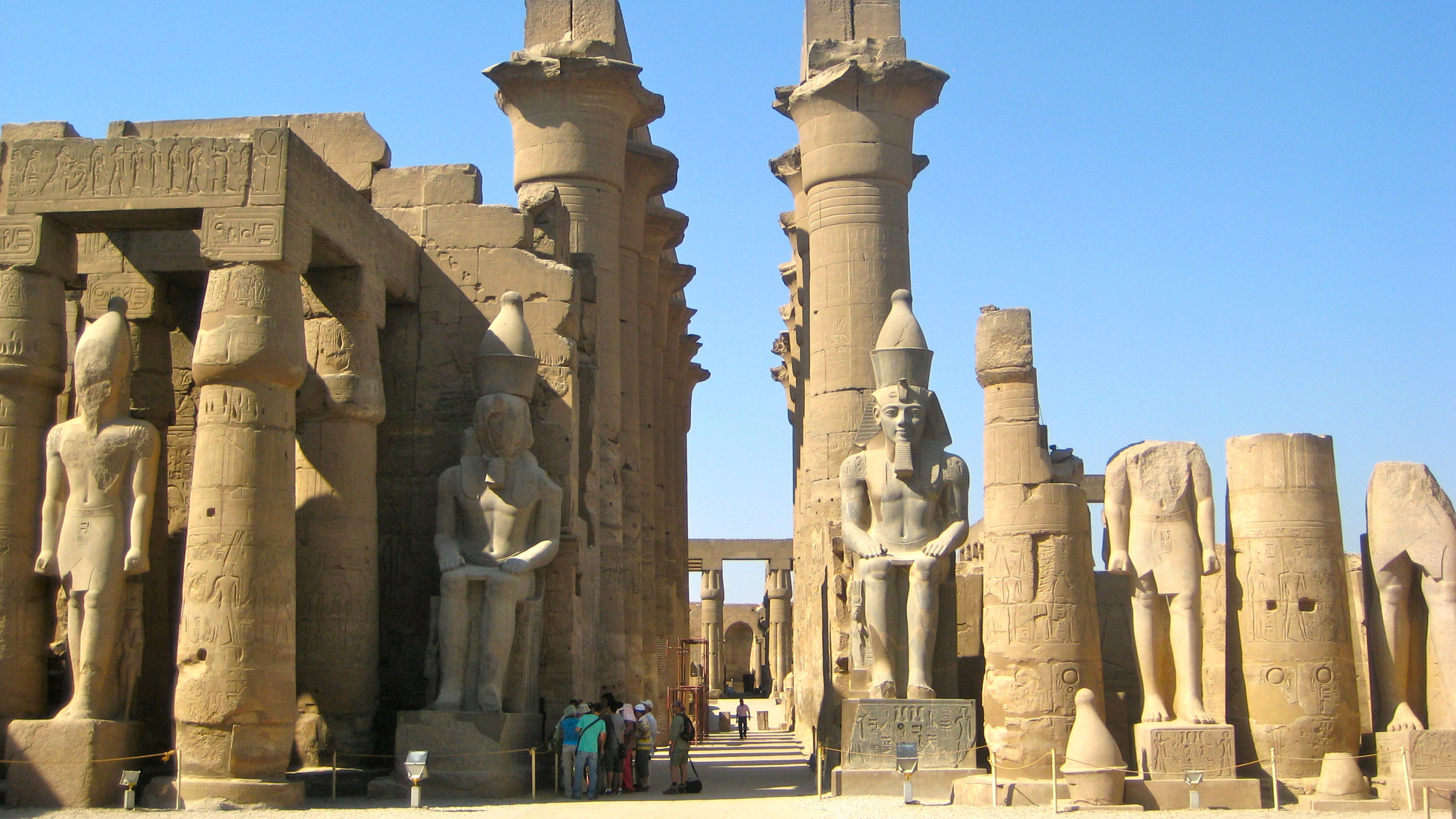 Gente Caminando Sobre Bloques de Hormigón Gris Durante el Día. Wallpaper in 2560x1440 Resolution