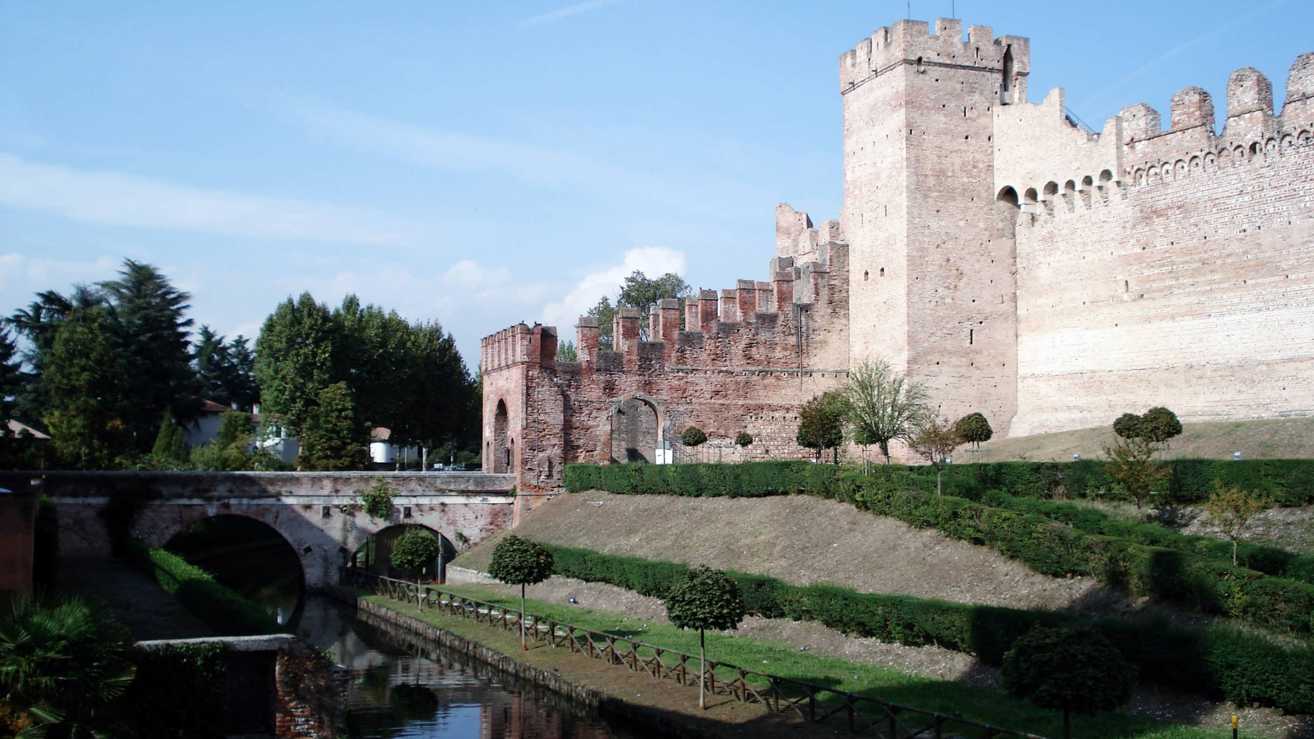 Brown Concrete Building Near River Under Blue Sky During Daytime. Wallpaper in 2560x1440 Resolution