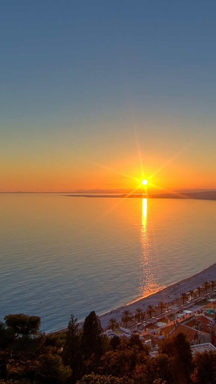 Horizonte de la Ciudad Cerca Del Mar Durante la Puesta de Sol. Wallpaper in 720x1280 Resolution