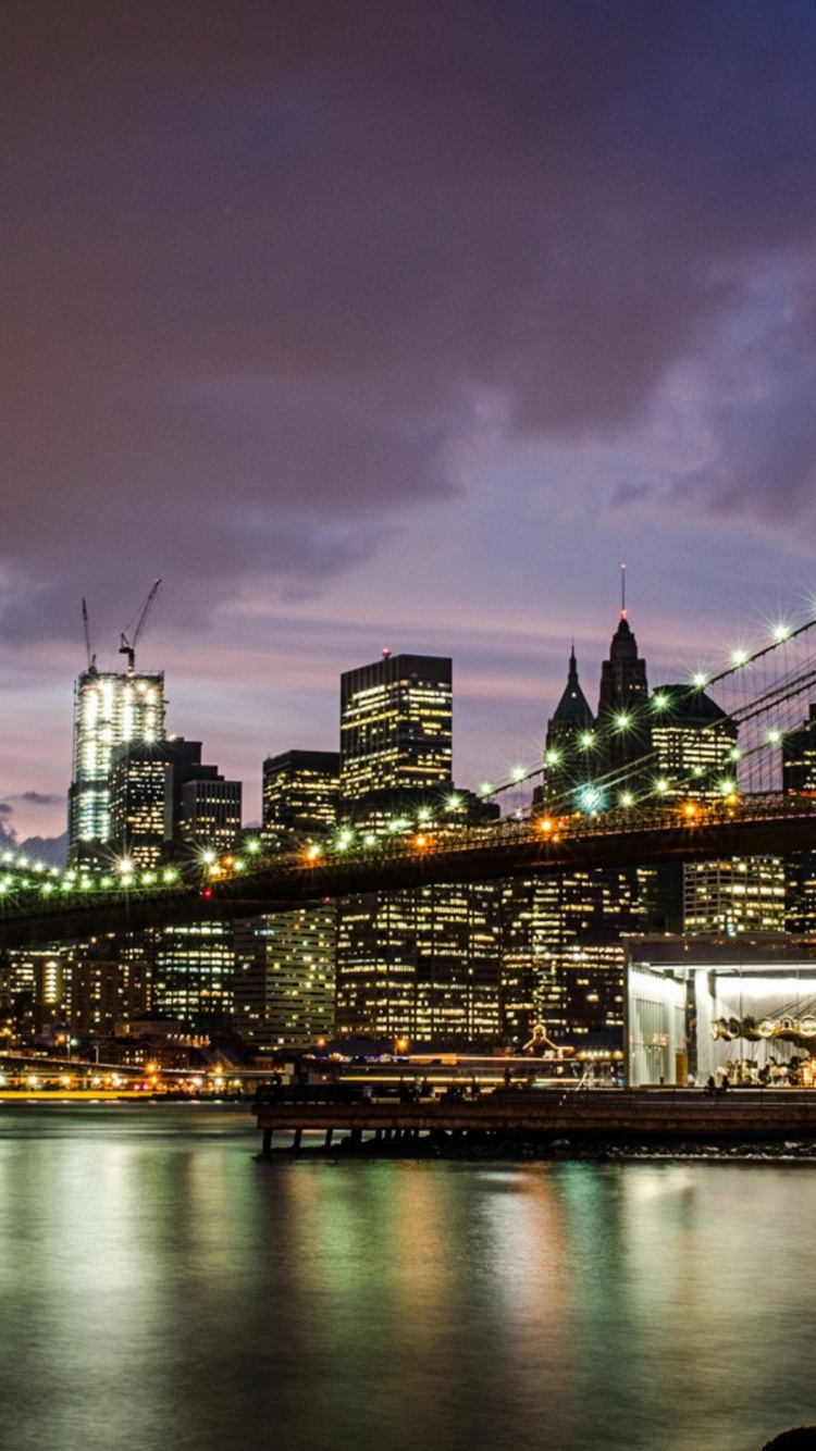 Puente Iluminado Sobre el Río Durante la Noche. Wallpaper in 750x1334 Resolution