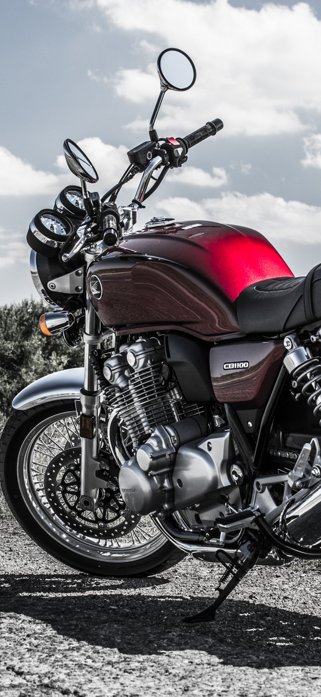 Rotes Und Schwarzes Motorrad Auf Grauer Schotterstraße Tagsüber. Wallpaper in 1125x2436 Resolution