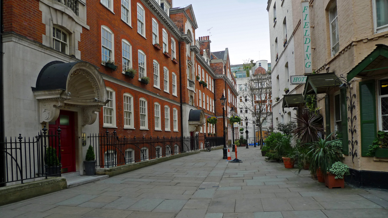 Leute, Die Tagsüber Auf Dem Bürgersteig in Der Nähe Eines Braunen Betongebäudes Gehen. Wallpaper in 1280x720 Resolution