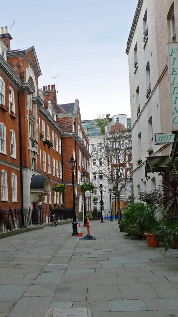 People Walking on Sidewalk Near Brown Concrete Building During Daytime. Wallpaper in 720x1280 Resolution