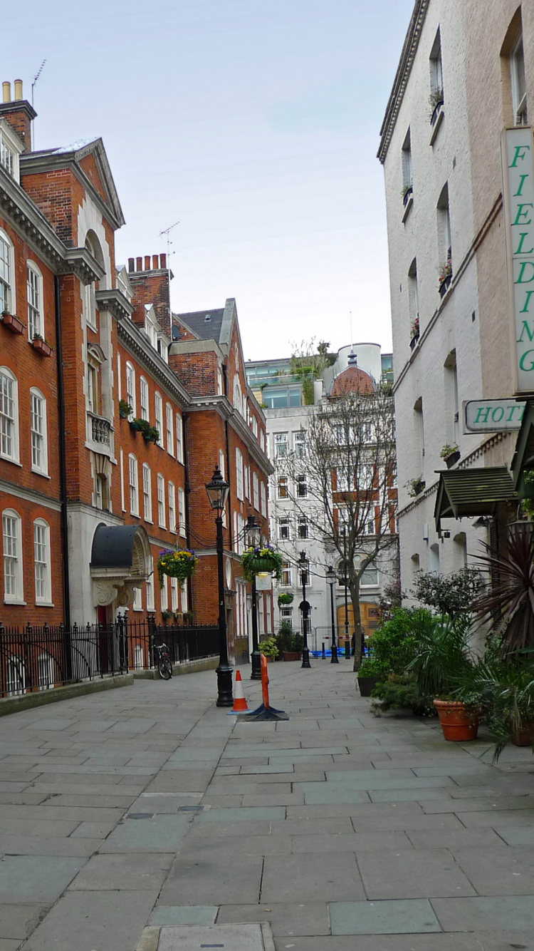 People Walking on Sidewalk Near Brown Concrete Building During Daytime. Wallpaper in 750x1334 Resolution