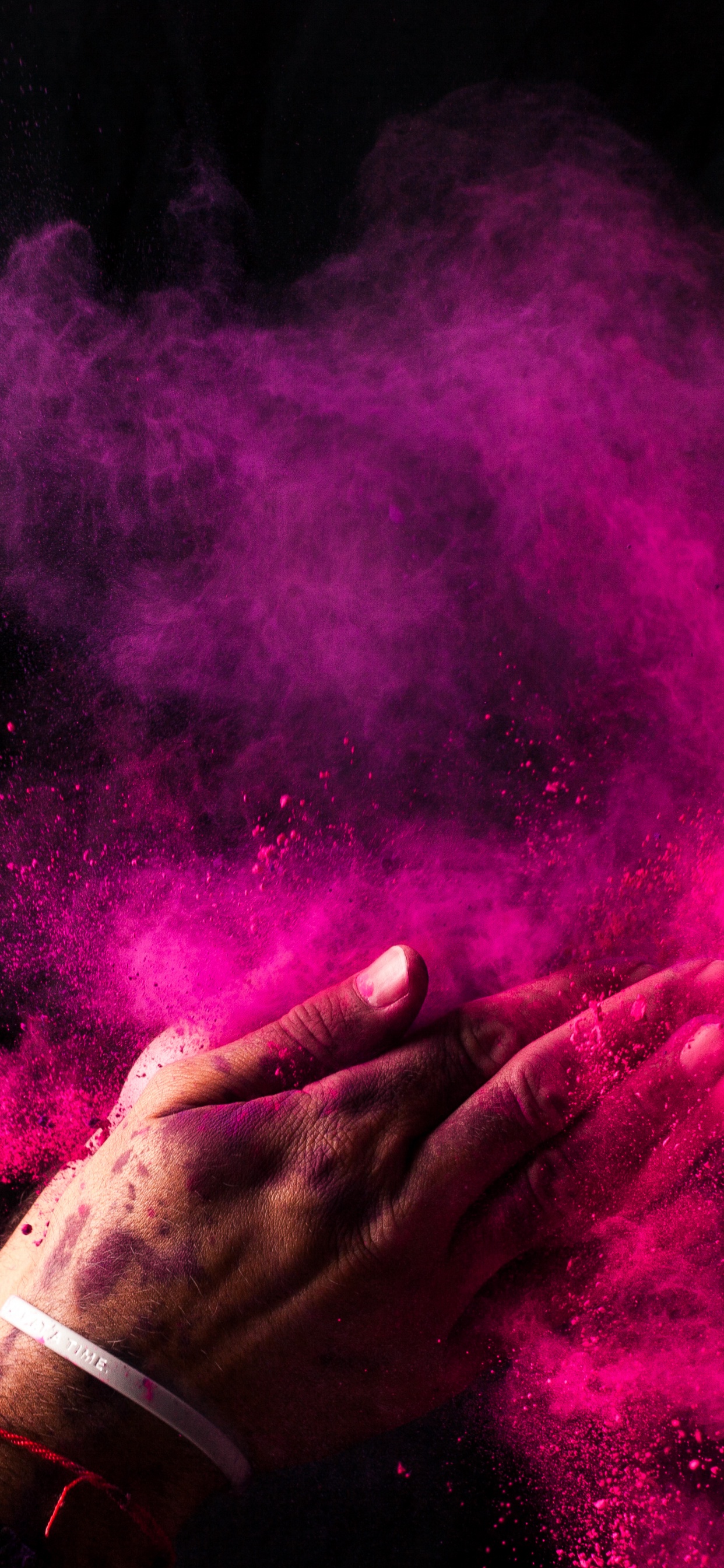 Person Holding Purple Powder in The Dark. Wallpaper in 1242x2688 Resolution