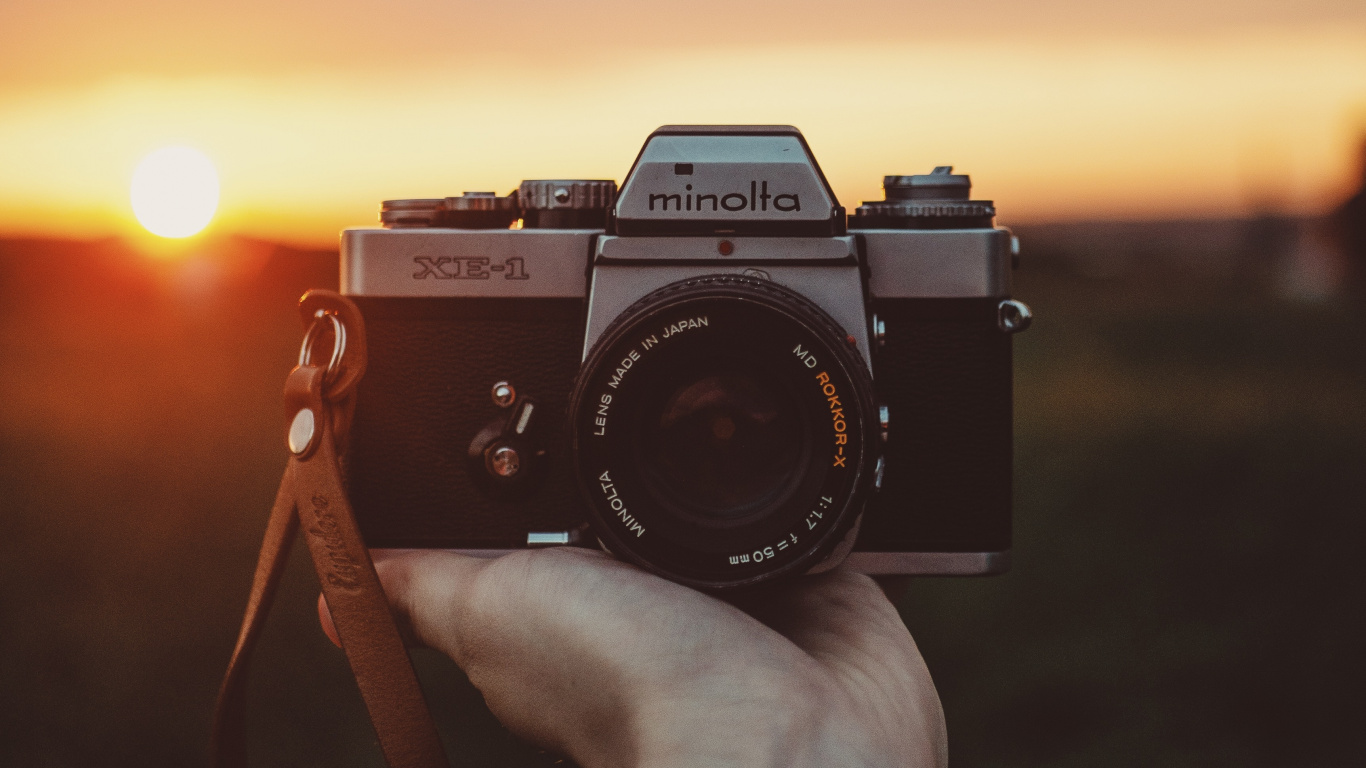 Person, Die Während Des Sonnenuntergangs Eine Schwarze Und Silberne Nikon-Dslr-Kamera Hält. Wallpaper in 1366x768 Resolution