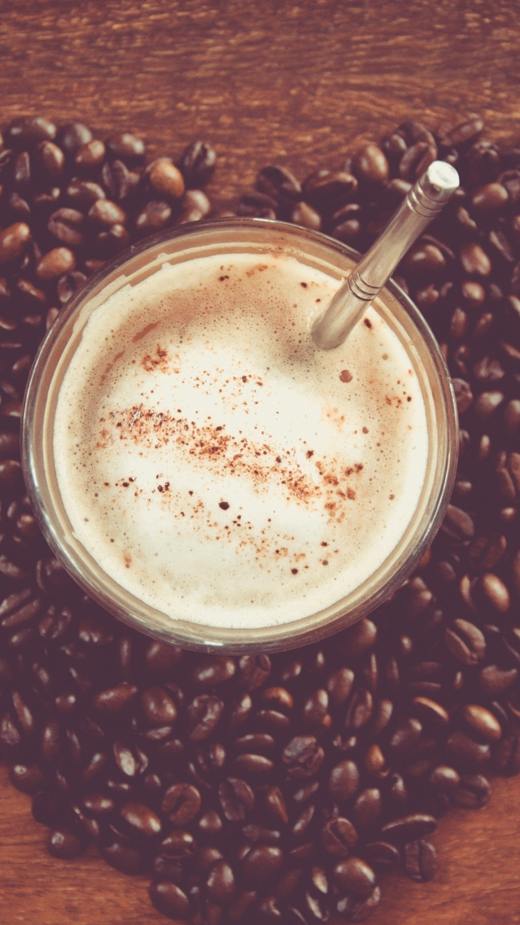 White Liquid in Clear Drinking Glass on Brown Coffee Beans. Wallpaper in 750x1334 Resolution