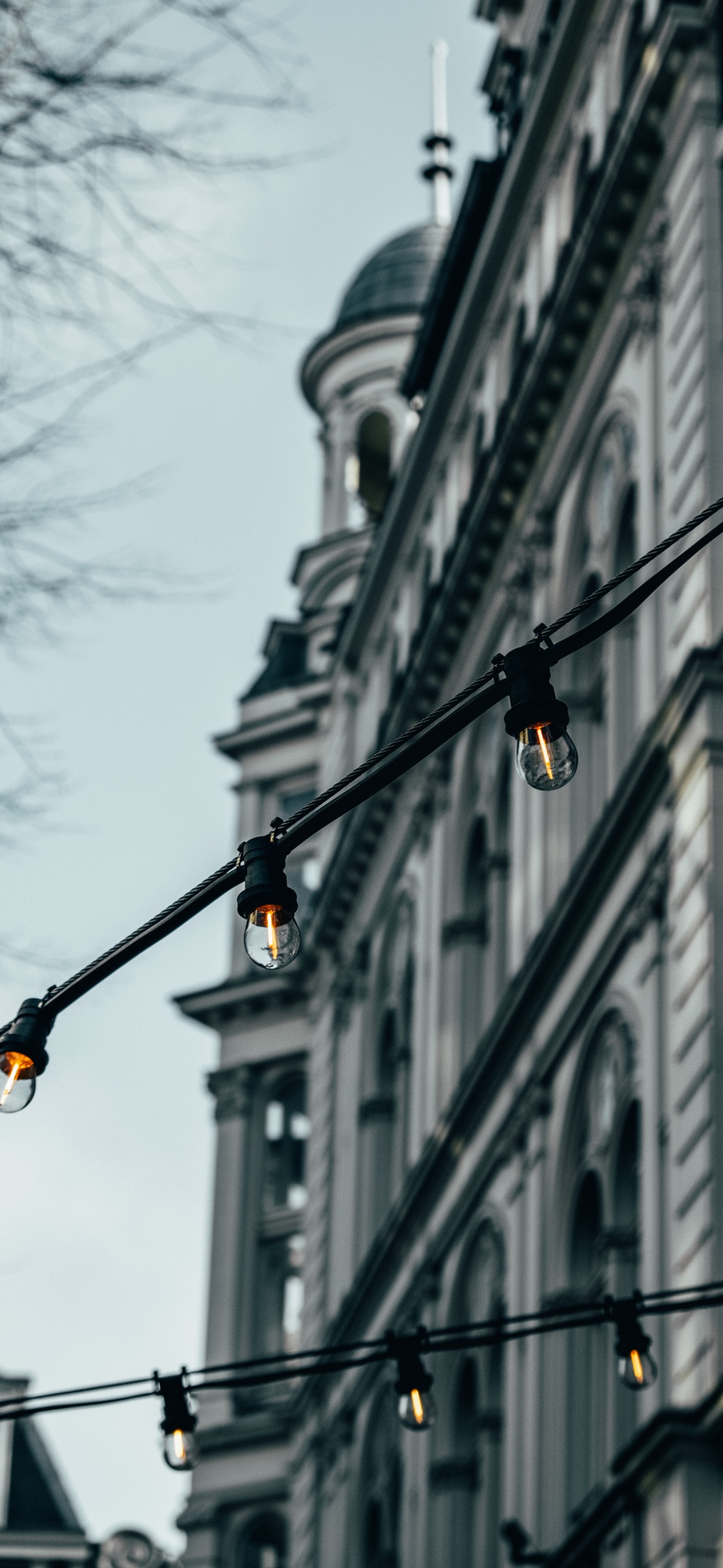 Poste de Luz Negra Cerca Del Edificio de Hormigón Blanco Durante el Día. Wallpaper in 1125x2436 Resolution