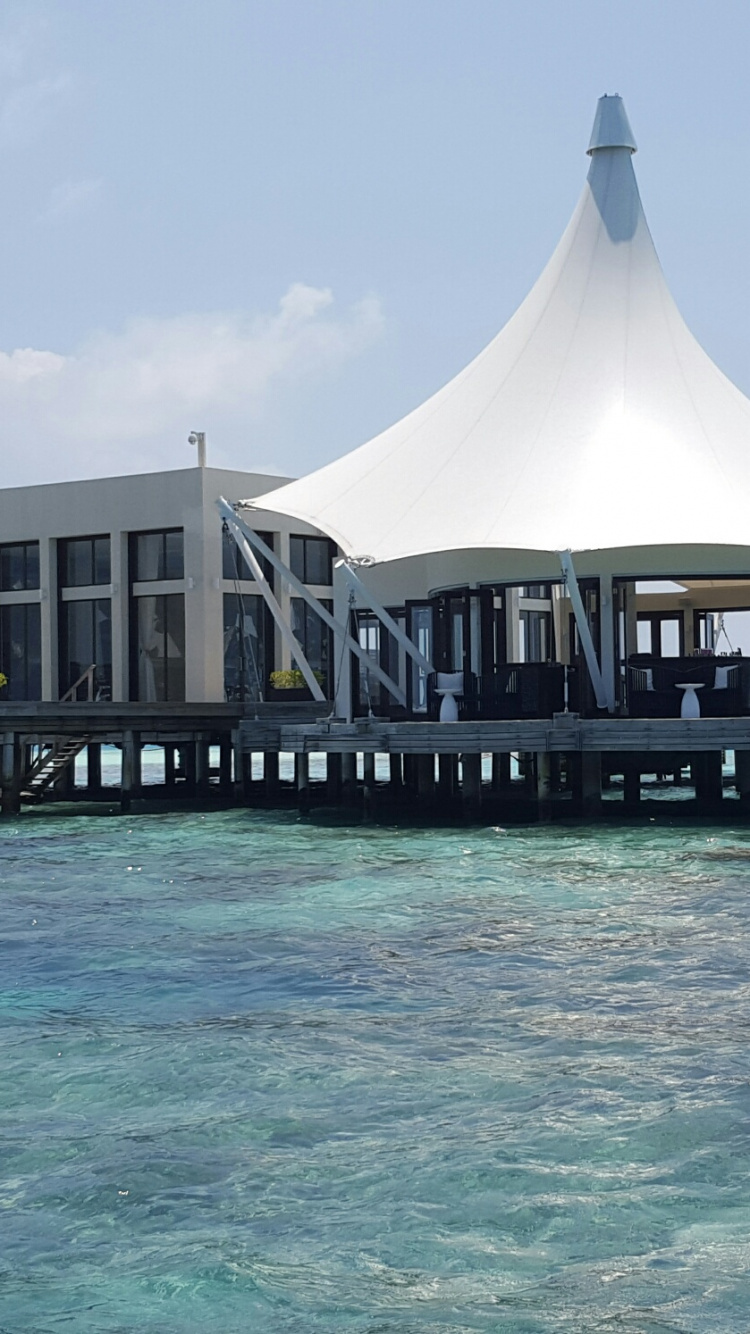 Brown Wooden Gazebo on Body of Water During Daytime. Wallpaper in 750x1334 Resolution