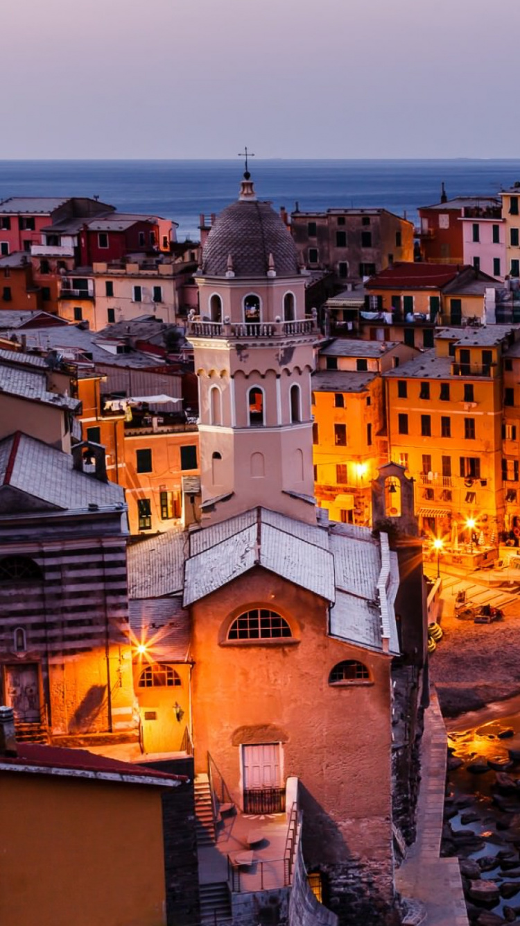 Edificio de Hormigón Blanco y Marrón Cerca Del Cuerpo de Agua Durante la Noche. Wallpaper in 750x1334 Resolution