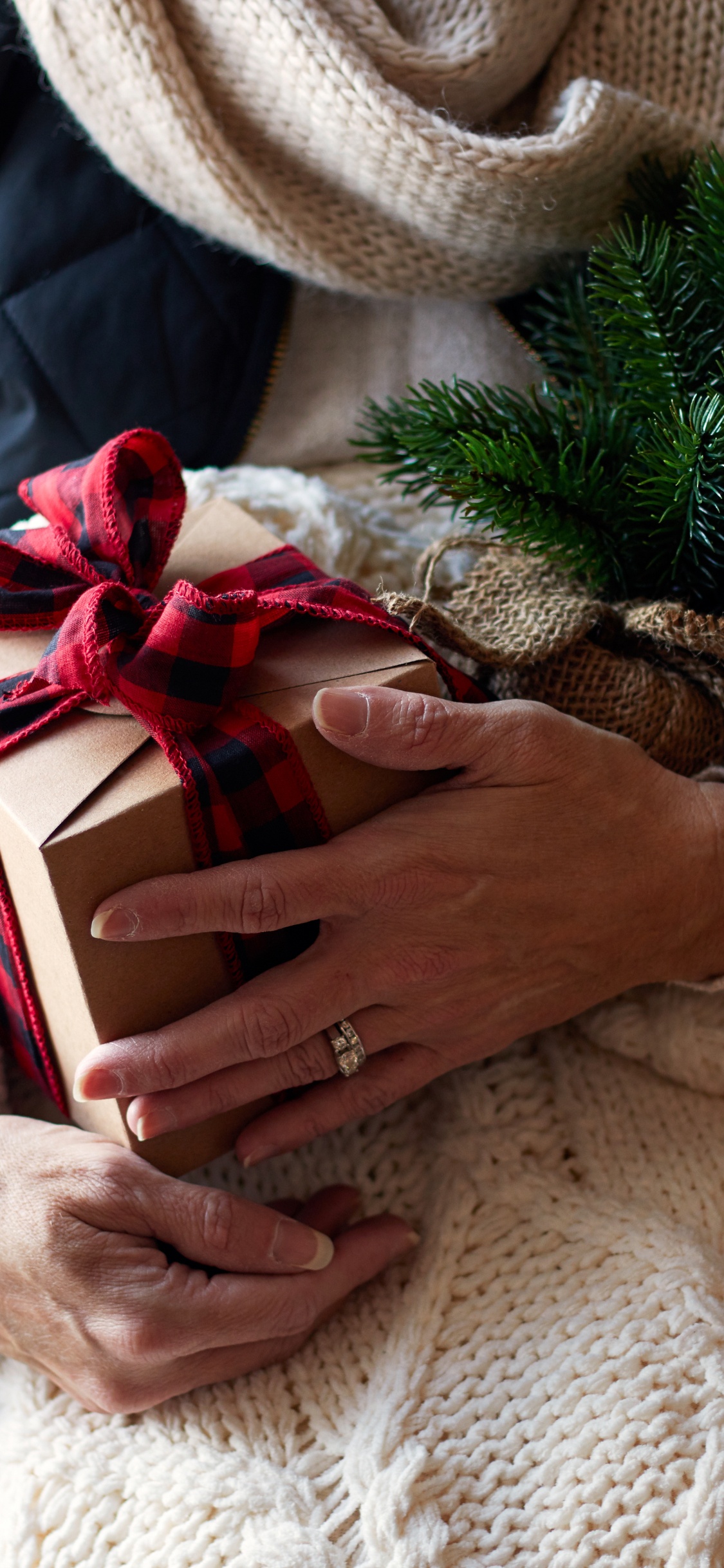 Woman in White Knit Sweater Holding Red and White Gift Box. Wallpaper in 1125x2436 Resolution