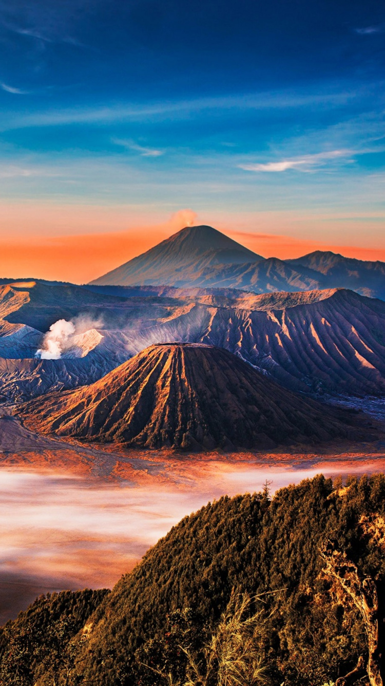 Brauner Berg Unter Blauem Himmel Tagsüber. Wallpaper in 750x1334 Resolution