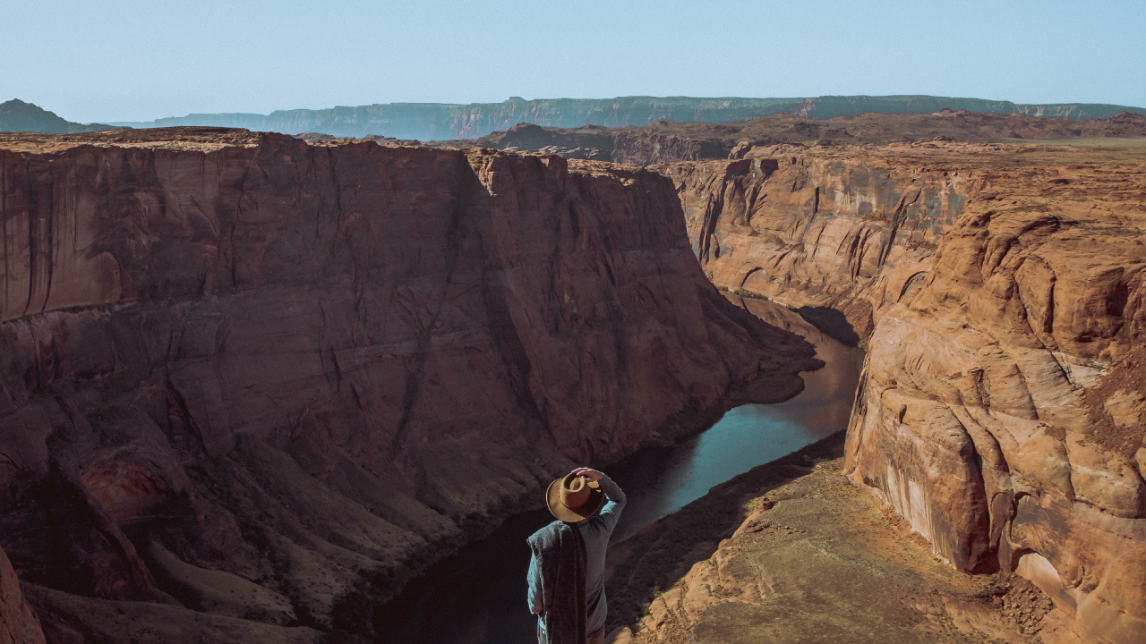Man in Black Jacket Standing on Brown Rock Formation During Daytime. Wallpaper in 1280x720 Resolution
