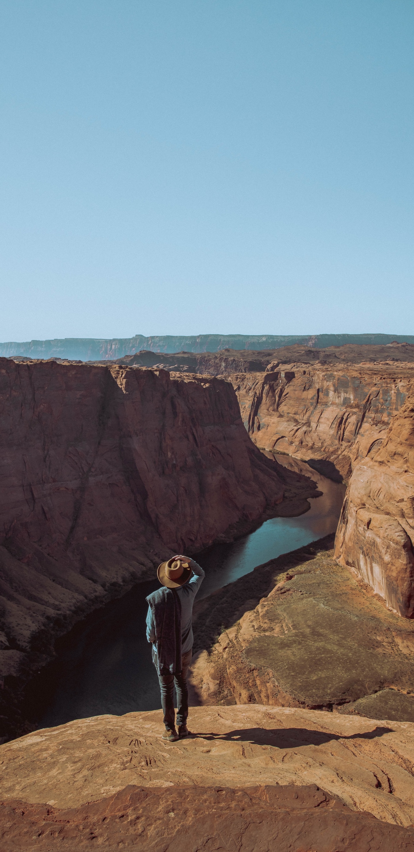 Man in Black Jacket Standing on Brown Rock Formation During Daytime. Wallpaper in 1440x2960 Resolution