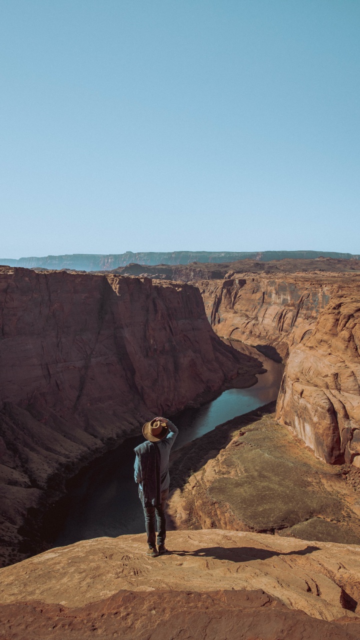 Man in Black Jacket Standing on Brown Rock Formation During Daytime. Wallpaper in 720x1280 Resolution