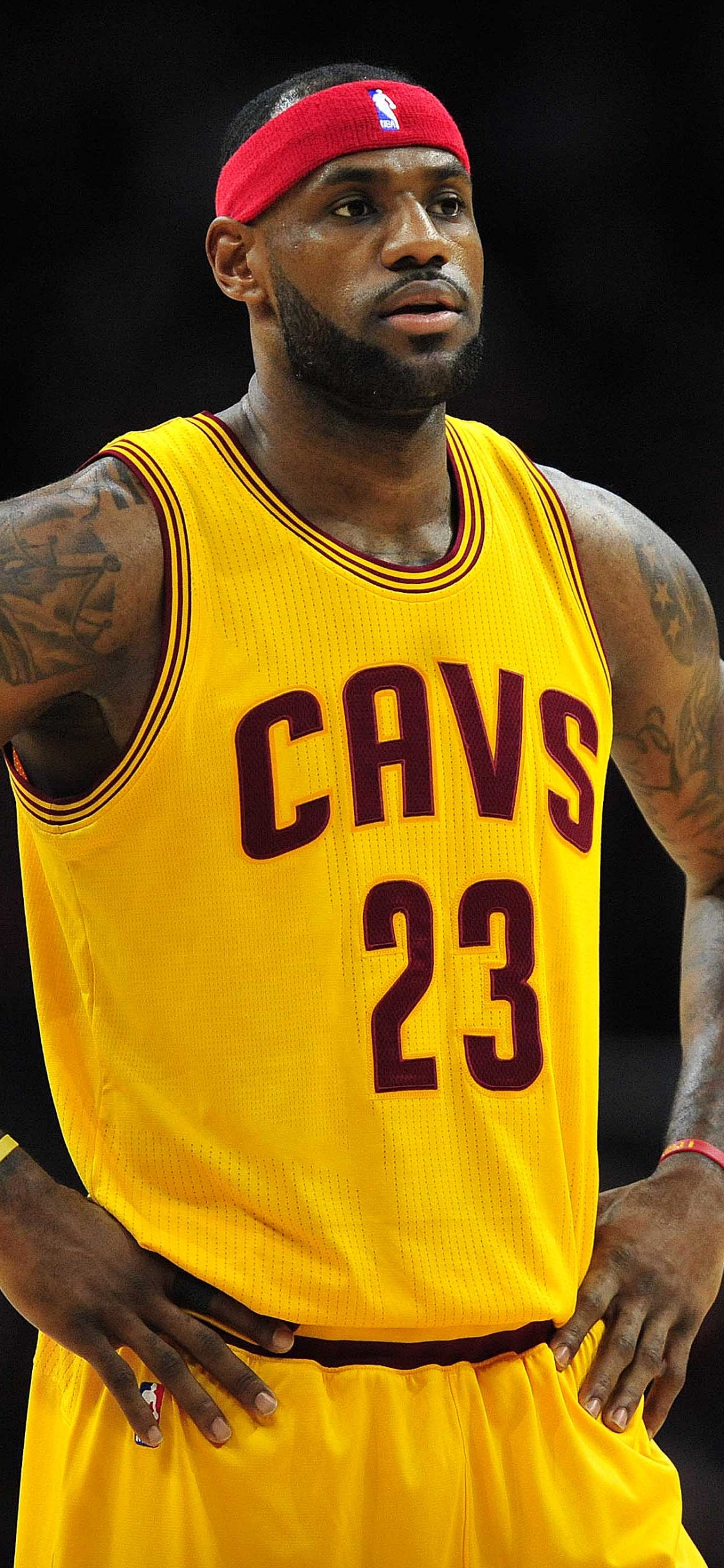 Man in Yellow and Red Nike Tank Top and Red Cap. Wallpaper in 1125x2436 Resolution