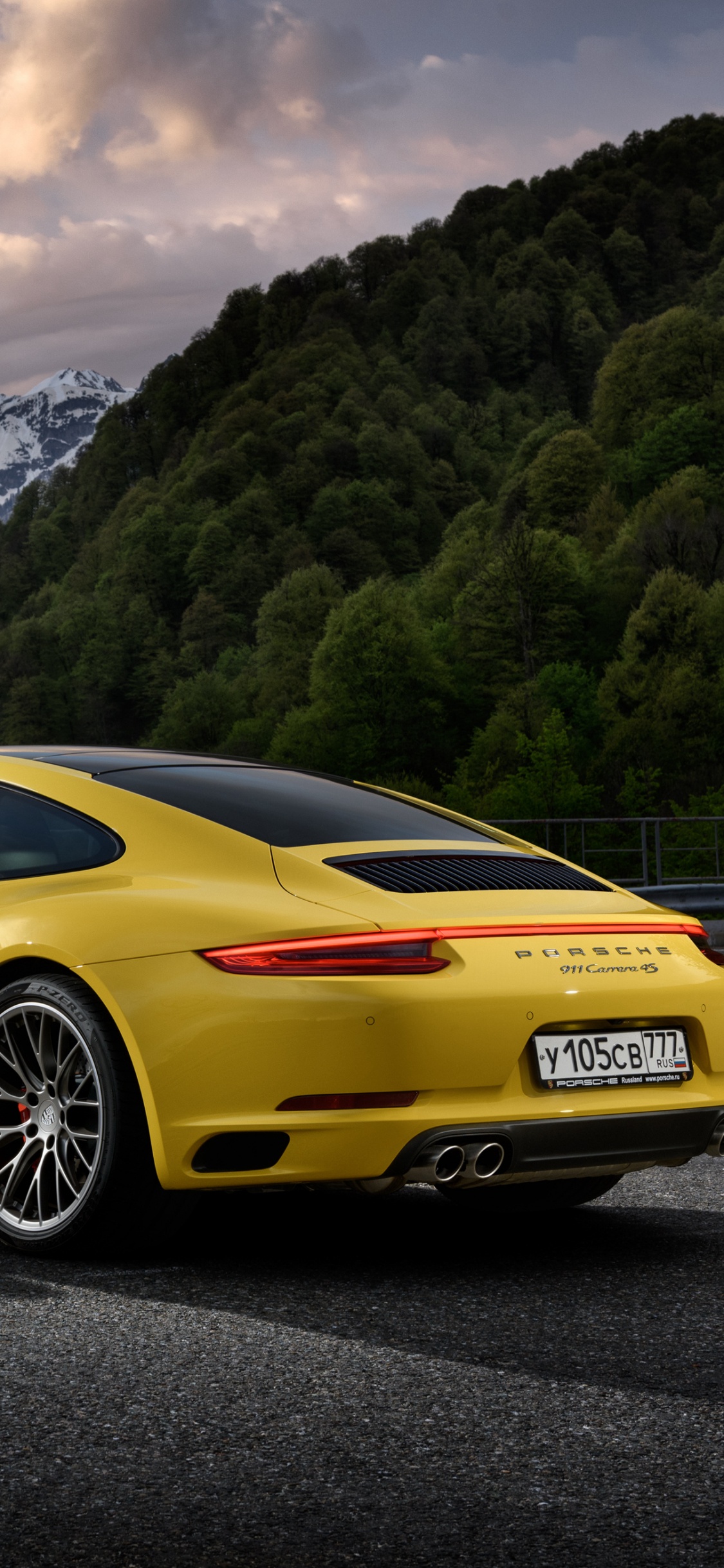 Porsche 911 Amarillo en la Carretera Cerca de la Montaña Durante el Día. Wallpaper in 1125x2436 Resolution